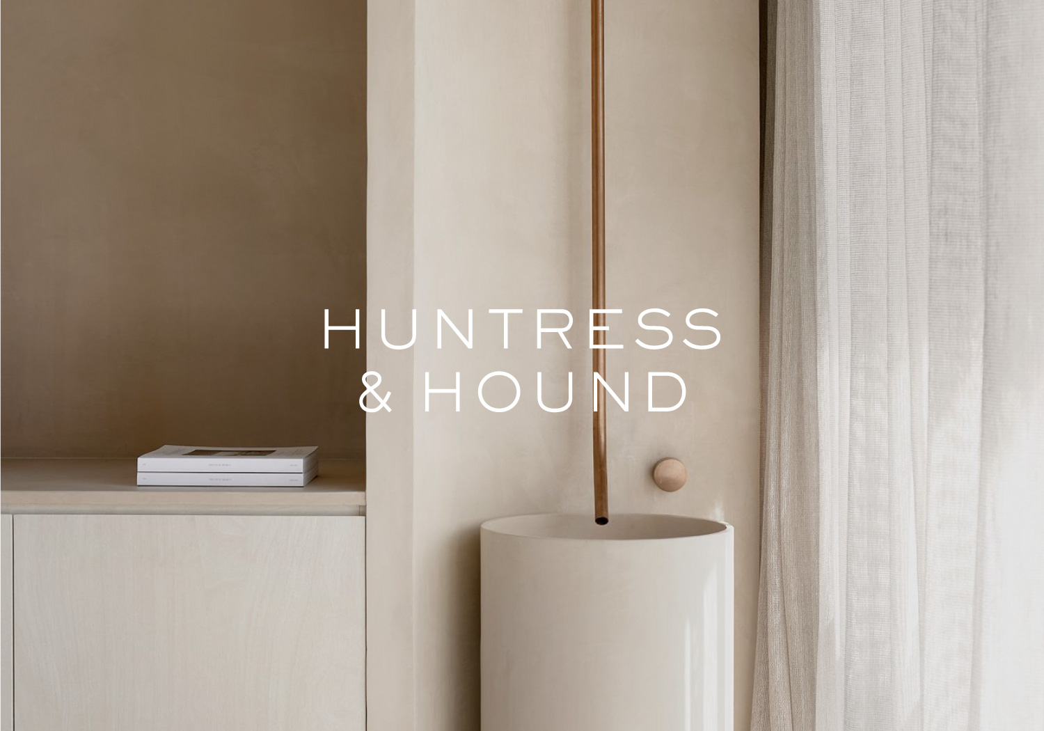 Huntress and Hound logo overlaid over a photo of a neautral coloured office space