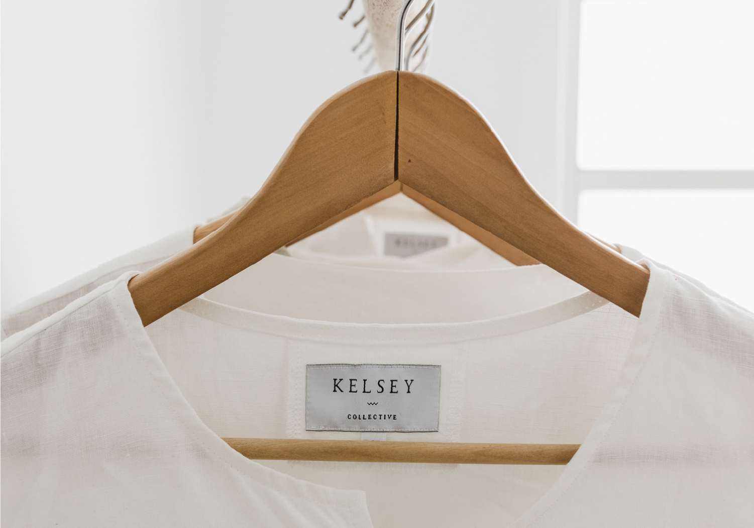 White linen garment on a a hanger with Kelsey Collective logo on stitch in tag