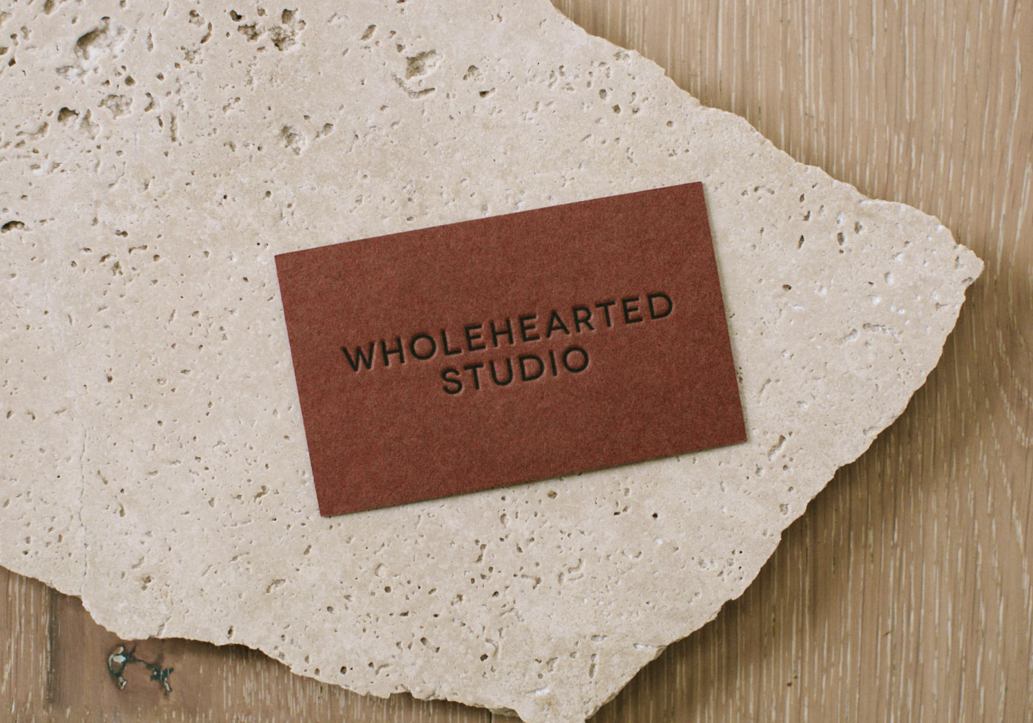Brown business card with black letterpress Wholehearted Studio logo