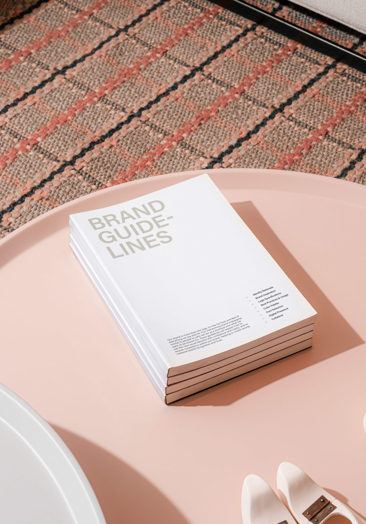 Brand guidelines booklet on top of a pink side table